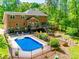 Serene backyard features a sparkling pool, spacious deck, and lush garden area at 7122 Forest Ridge Rd, Matthews, NC 28104