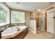 This bathroom features a soaking tub, glass shower, and beautiful tile accents at 7122 Forest Ridge Rd, Matthews, NC 28104