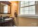 Elegant half bathroom featuring a dark vanity, granite countertop, and natural light at 7122 Forest Ridge Rd, Matthews, NC 28104