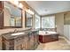 This bathroom features a soaking tub, double vanity, and beautiful natural light at 7122 Forest Ridge Rd, Matthews, NC 28104
