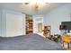 A tidy bedroom features light blue walls, a ceiling fan, and doorway to a sunny, adjacent room at 7122 Forest Ridge Rd, Matthews, NC 28104