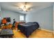 Comfortable bedroom featuring hardwood floors, ample natural light, and a ceiling fan at 7122 Forest Ridge Rd, Matthews, NC 28104