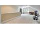 Bright bonus room with neutral carpet, desk with sewing machine, and exercise equipment at 7122 Forest Ridge Rd, Matthews, NC 28104