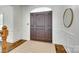 Elegant foyer showcasing a solid wood door, wainscoting, and hardwood floors at 7122 Forest Ridge Rd, Matthews, NC 28104
