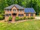 Stately brick home with solar panels, manicured landscaping, and inviting entryway at 7122 Forest Ridge Rd, Matthews, NC 28104