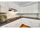 Well-lit kitchen featuring sleek black countertops, white cabinets, and stainless steel appliances at 7122 Forest Ridge Rd, Matthews, NC 28104