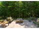 Beautiful backyard featuring lush greenery and a stone fire pit with comfortable seating, ideal for outdoor relaxation at 733 Lingfield Ln, Waxhaw, NC 28173