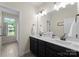 Bathroom featuring a double vanity with dark cabinets, white countertops, and framed mirror at 733 Lingfield Ln, Waxhaw, NC 28173