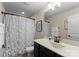 Bathroom showcasing a dark vanity, white countertop, shower with white curtain, and framed mirror at 733 Lingfield Ln, Waxhaw, NC 28173