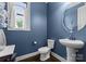 Powder room with pedestal sink, round mirror, and blue walls at 733 Lingfield Ln, Waxhaw, NC 28173