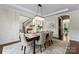 Formal dining room features chandelier, wainscoting, view into the kitchen and dark wood floors at 733 Lingfield Ln, Waxhaw, NC 28173