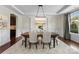 Formal dining room with elegant chandelier, tray ceiling, wainscoting and large window for natural light at 733 Lingfield Ln, Waxhaw, NC 28173