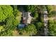 An aerial shot shows a well-kept home with beautiful landscaping and a detached garage amidst a canopy of trees at 8222 Henry Harris Rd, Fort Mill, SC 29707