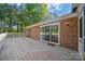 Expansive back deck made of wood with sliding glass doors, brick exterior, and a white railing at 8222 Henry Harris Rd, Fort Mill, SC 29707