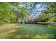 Lush backyard featuring mature trees, a well-maintained lawn, and vibrant azaleas for colorful landscaping at 8222 Henry Harris Rd, Fort Mill, SC 29707