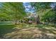 Inviting brick home features a covered front porch and well-manicured lawn with mature trees at 8222 Henry Harris Rd, Fort Mill, SC 29707