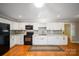 Modern kitchen with white cabinetry, subway tile backsplash, black appliances, and gleaming hardwood floors at 8222 Henry Harris Rd, Fort Mill, SC 29707