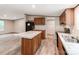 Open kitchen with center island, modern appliances, wooden cabinets, and wood-look flooring extending into living space at 850 Deep Hollow Ct, Clover, SC 29710