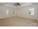 Spacious bedroom featuring neutral carpet, a ceiling fan, and multiple windows for ample natural light at 8709 Stratton Farm Rd, Huntersville, NC 28078