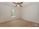 Bedroom featuring carpet floor, window with green view, and a ceiling fan with lights at 8709 Stratton Farm Rd, Huntersville, NC 28078