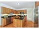 Well-lit kitchen with wood cabinets, stainless steel appliances, and a center island featuring black granite countertops at 8709 Stratton Farm Rd, Huntersville, NC 28078