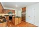 Functional kitchen featuring wooden cabinets, an island with a granite countertop, and stainless steel appliances at 8709 Stratton Farm Rd, Huntersville, NC 28078