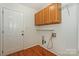 Functional laundry room with overhead cabinets, a utility sink hookup, and a door to the exterior at 8709 Stratton Farm Rd, Huntersville, NC 28078