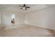 Large bedroom with neutral carpet, tray ceiling, and ample natural light from multiple windows at 8709 Stratton Farm Rd, Huntersville, NC 28078