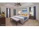Staged bedroom with a tray ceiling, carpet, two side tables, a bench, and three windows at 8709 Stratton Farm Rd, Huntersville, NC 28078