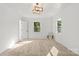 Inviting bedroom features a modern light fixture, dual windows, and neutral carpet at 910 Lightwood Dr, Matthews, NC 28105