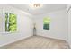 Bright bedroom featuring dual windows offering lush green outdoor views and neutral carpet at 910 Lightwood Dr, Matthews, NC 28105