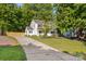 Two-story home with white siding and black shutters situated on a large lot with mature trees at 910 Lightwood Dr, Matthews, NC 28105