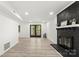Cozy living room featuring a painted brick fireplace, stylish floors, and French doors to backyard at 910 Lightwood Dr, Matthews, NC 28105