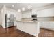 Modern kitchen with white cabinets, stainless steel appliances, and granite countertops at 9849 Steele Meadow Rd, Charlotte, NC 28273