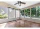 Cozy sunroom features wood-look floors, ceiling fan, and abundant natural light from the many windows at 9849 Steele Meadow Rd, Charlotte, NC 28273