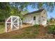 Charming detached garage and greenhouse are nestled among mature trees, perfect for gardening and storage at 105 Horsestable Ct, Mooresville, NC 28115