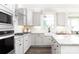Bright, well-lit kitchen with white cabinets, granite countertops, stainless steel appliances, and a farmhouse sink at 105 Nighthawk Trl # 20, Mooresville, NC 28115