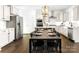Stylish kitchen with white cabinets, stainless steel appliances, large island, wooden floor, and modern lighting at 107 Nighthawk Trl # 21, Mooresville, NC 28115