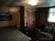 Bedroom featuring a bed, loveseat, and dark wood paneled walls at 1210 Congress St, Gastonia, NC 28054
