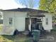 Weathered, white single-story home with a covered porch needing repair, and miscellaneous items littering the lawn at 1210 Congress St, Gastonia, NC 28054