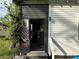 A view of a home's entryway with greenery and a weathered facade at 1210 Congress St, Gastonia, NC 28054