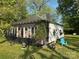 Charming single-story house featuring a cozy screened-in porch and a blue patio chair on a sunny lawn at 1210 Congress St, Gastonia, NC 28054
