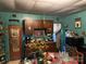 A view of the kitchen that includes cabinets, appliances, and a table covered in assorted items at 1210 Congress St, Gastonia, NC 28054