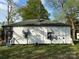 The back of the home has white wood paneling, a small set of awning windows, and a blue patio chair at 1210 Congress St, Gastonia, NC 28054