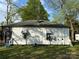 The back of the home has white wood paneling, a small set of awning windows, and a blue patio chair at 1210 Congress St, Gastonia, NC 28054