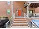 Brick building entryway with stairs, bright red door, and white wrought iron railing at 123 Carriage House Dr, Kannapolis, NC 28081