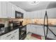Well-lit kitchen showcasing ample white cabinets, black appliances, granite countertops, and tiled backsplash at 123 Carriage House Dr, Kannapolis, NC 28081