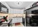 Well-lit kitchen showcasing ample white cabinets, black appliances, granite countertops, and tiled backsplash at 123 Carriage House Dr, Kannapolis, NC 28081