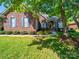 Charming brick home with well-manicured lawn and mature trees offering a welcoming curb appeal at 1257 Mill Race Ln, Matthews, NC 28104