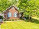 Beautiful brick home featuring lush green lawn, mature trees, and a welcoming front facade at 1257 Mill Race Ln, Matthews, NC 28104
